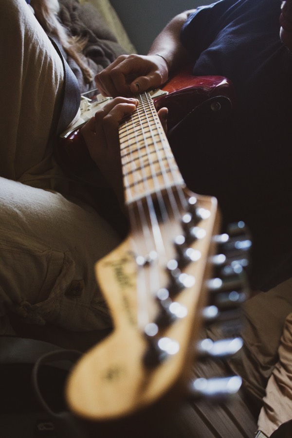 Man playing electric guitar relaxing at home